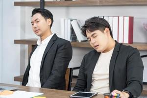 Business team members sleeping on desk and chairs. A business team is tired from a long meeting. photo
