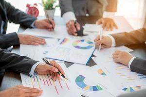 Group professional business people person working together to analyze in office, work together to discuss company financial statistics report, brainstorm ideas, and graph datum documents on the table. photo