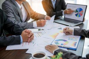 Group professional business people person working together to analyze in office, work together to discuss company financial statistics report, brainstorm ideas, and graph datum documents on the table. photo