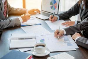 Group professional business people person working together to analyze in office, work together to discuss company financial statistics report, brainstorm ideas, and graph datum documents on the table. photo