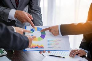 Group professional business people person working together to analyze in office, work together to discuss company financial statistics report, brainstorm ideas, and graph datum documents on the table. photo