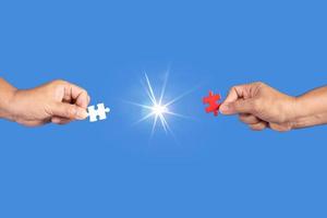 Hands holding jigsaw puzzles piece with clear blue background, success business, solution strategy, teamwork partnership concept photo