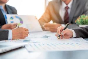 Group professional business people person working together to analyze in office, work together to discuss company financial statistics report, brainstorm ideas, and graph datum documents on the table. photo