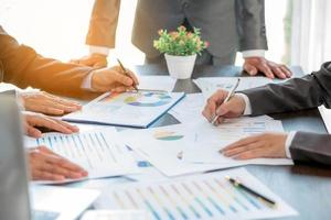 Group professional business people person working together to analyze in office, work together to discuss company financial statistics report, brainstorm ideas, and graph datum documents on the table. photo