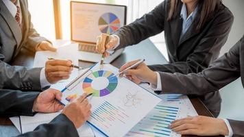 Group professional business people person working together to analyze in office, work together to discuss company financial statistics report, brainstorm ideas, and graph datum documents on the table. photo