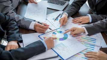 Group professional business people person working together to analyze in office, work together to discuss company financial statistics report, brainstorm ideas, and graph datum documents on the table. photo