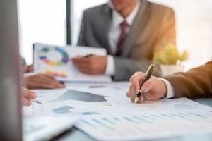 Group professional business people person working together to analyze in office, work together to discuss company financial statistics report, brainstorm ideas, and graph datum documents on the table. photo