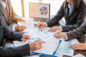 Group professional business people person working together to analyze in office, work together to discuss company financial statistics report, brainstorm ideas, and graph datum documents on the table. photo