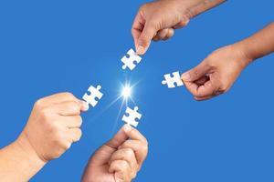 Hands holding jigsaw puzzles piece with clear blue background, success business, solution strategy, teamwork partnership concept photo