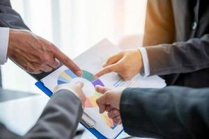Group professional business people person working together to analyze in office, work together to discuss company financial statistics report, brainstorm ideas, and graph datum documents on the table. photo