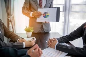 Group professional business people person working together to analyze in office, work together to discuss company financial statistics report, brainstorm ideas, and graph datum documents on the table. photo