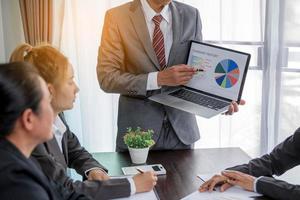 Group professional business people person working together to analyze in office, work together to discuss company financial statistics report, brainstorm ideas, and graph datum documents on the table. photo