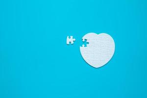 White heart shape of jigsaw puzzle pieces on blue background. concepts of problem solving, business success, teamwork, Team playing jigsaw game incomplete, Texture banner with copy space for text photo