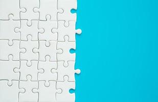 White part of jigsaw puzzle pieces on blue background. concepts of problem solving, business success, teamwork, Team playing jigsaw game incomplete, Texture photo with copy space for text