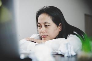 Stress business woman person from hard work, depression in office. Tired and anxious employee female with unhappy at problem job. young businesswoman sitting sad front of laptop computer on desk. photo