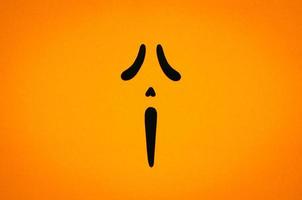 Spooky ghost face with orange background for Halloween minimal background concept. photo