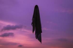 Ghost sheet flying in dusk sky background. Halloween scary concept. photo