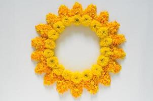 flores decorativas de caléndula de color amarillo y naranja y rangoli de pétalos para el festival de diwali con fondo de espacio en blanco. foto