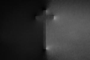 The cross pressing through black fabric with shine and dark side for Halloween background concept. photo