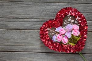 Tinsel heart  decoration on wood background photo