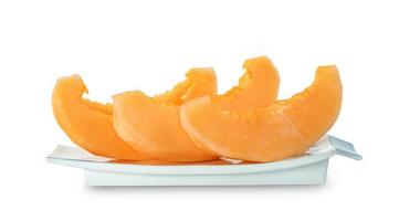 Fruta de melón cantalupo naranja cortada en un plato aislado en fondo blanco, incluye ruta de recorte