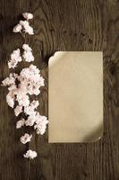 brown paper and pink flowers on wooden background,filter effect. photo