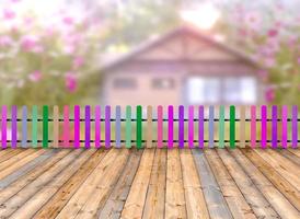 valla de madera multicolor y suelo de madera con casa borrosa en el fondo del bosque foto