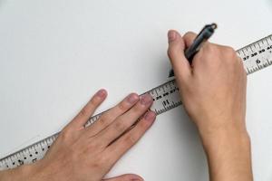hand holding ruler and clutch-type pencil with canvas background photo