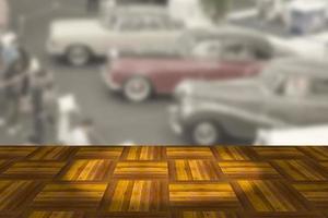 Empty wooden board space platform with vintage car show room blurry background photo