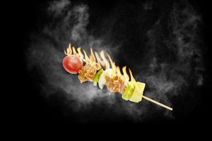 skewer of mixed meat and vegetables on the grill photo