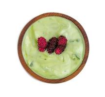 mezcla de yogur sabor a té verde en polvo con nata de coco dutchie y moras fruta en tazón de madera aislado sobre fondo blanco, incluye trazado de recorte foto