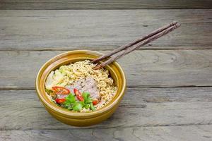 instant noodle in a bowl on a wooden background. photo