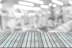 Empty wooden board space platform with blur fitness gym equipment background photo