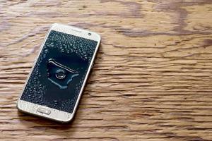 wet smartphone drops on wooden floor photo