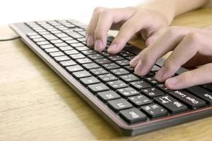 primer plano de escribir manos masculinas en el teclado negro, concepto de trabajo de hombre de negocios, efecto de luz foto