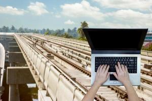Woman using laptop with blurry metro background photo