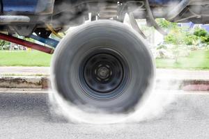 Off-road car spinning wheel burns rubber on floor photo