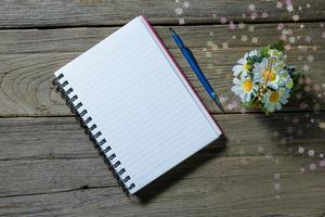 open note book with clutch-type pencil on wood background photo