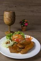 Grilled steak meat with vegetable salad on wood background photo