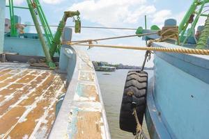 protección de parachoques de neumáticos al lado del barco foto