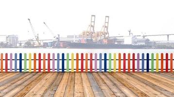 Varicolored wooden fence and floor wood with cargo ship background photo