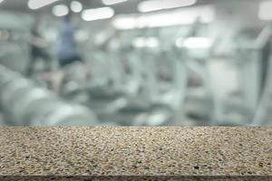 stone table with blur fitness gym equipment background photo