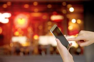 Hands holding mobile smartphone with restaurant concept blurred Background photo