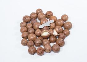 Open Macadamia nut by tool on background photo
