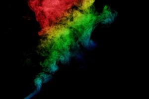 humo abstracto aislado sobre fondo negro, polvo de arco iris foto