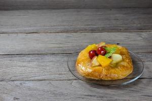 pastelería danesa con frutas sobre fondo de madera foto