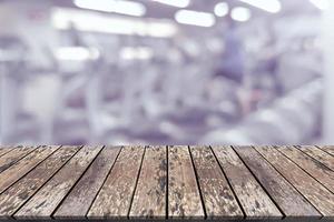 plataforma espacial de tablero de madera vacía con fondo de equipo de gimnasio de fitness borroso foto