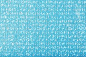 la textura de la película de burbujas de aire de embalaje sobre un fondo azul en pantalla completa foto
