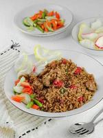 Fried rice with sausage and vegetables, cucumber, carrots, crackers photo