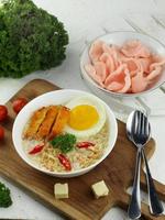 boiled soup with noodles and eggs crisp served in a bowl with chili and celery photo